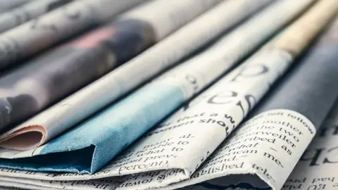 Foldede aviser i bunke