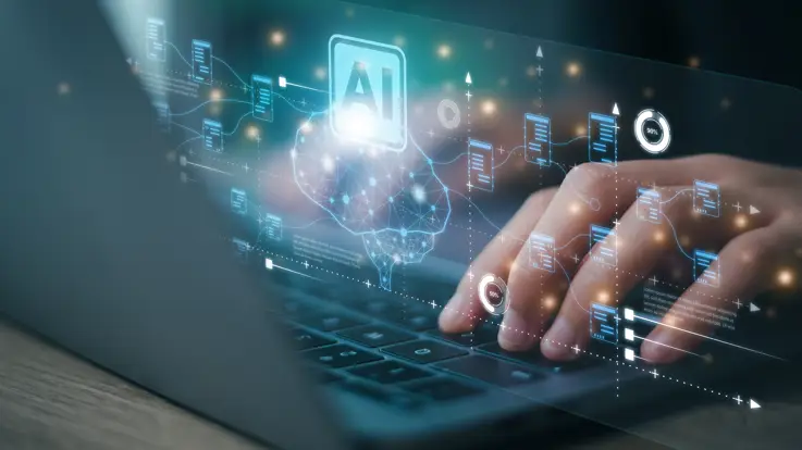 En person taster på en bærbar computer med AI-grafik, der kommer op ad tastaturet.