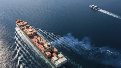 Containerskib sejler ved siden af lille båd