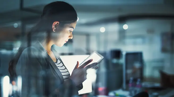 Kvinde står med en tablet