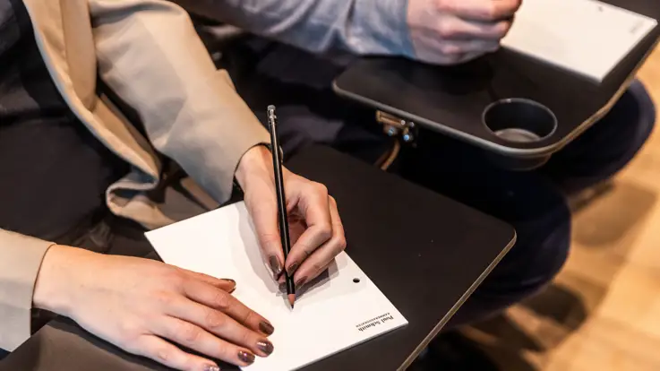 Kvinde tager noter til et event