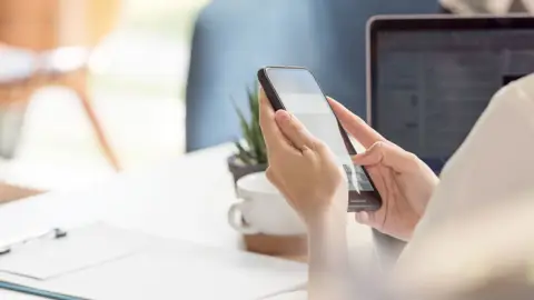 En person er i gang med at bruge en mobiltelefon.